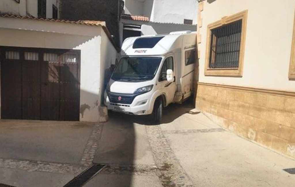 Buitenlandse kampeerautotoerist rijdt zich klem in smalle straat in Granada